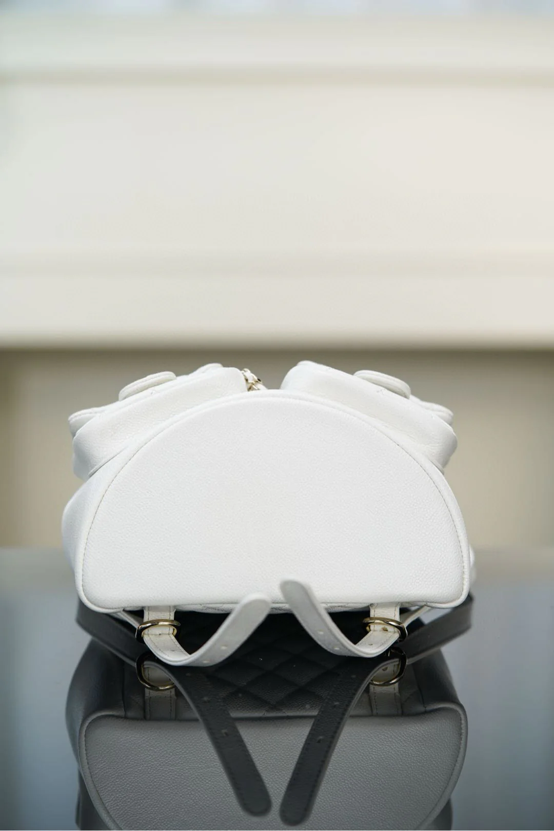 Рюкзак Chanel Duma 24a, белый с золотой пряжкой.