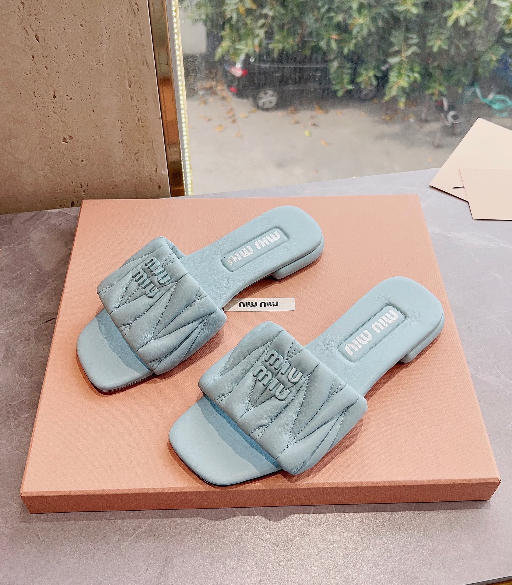 Новинка сезона весна/лето 2023 от Miu Miu - плоские тапочки из овечьей кожи - светло-серые.