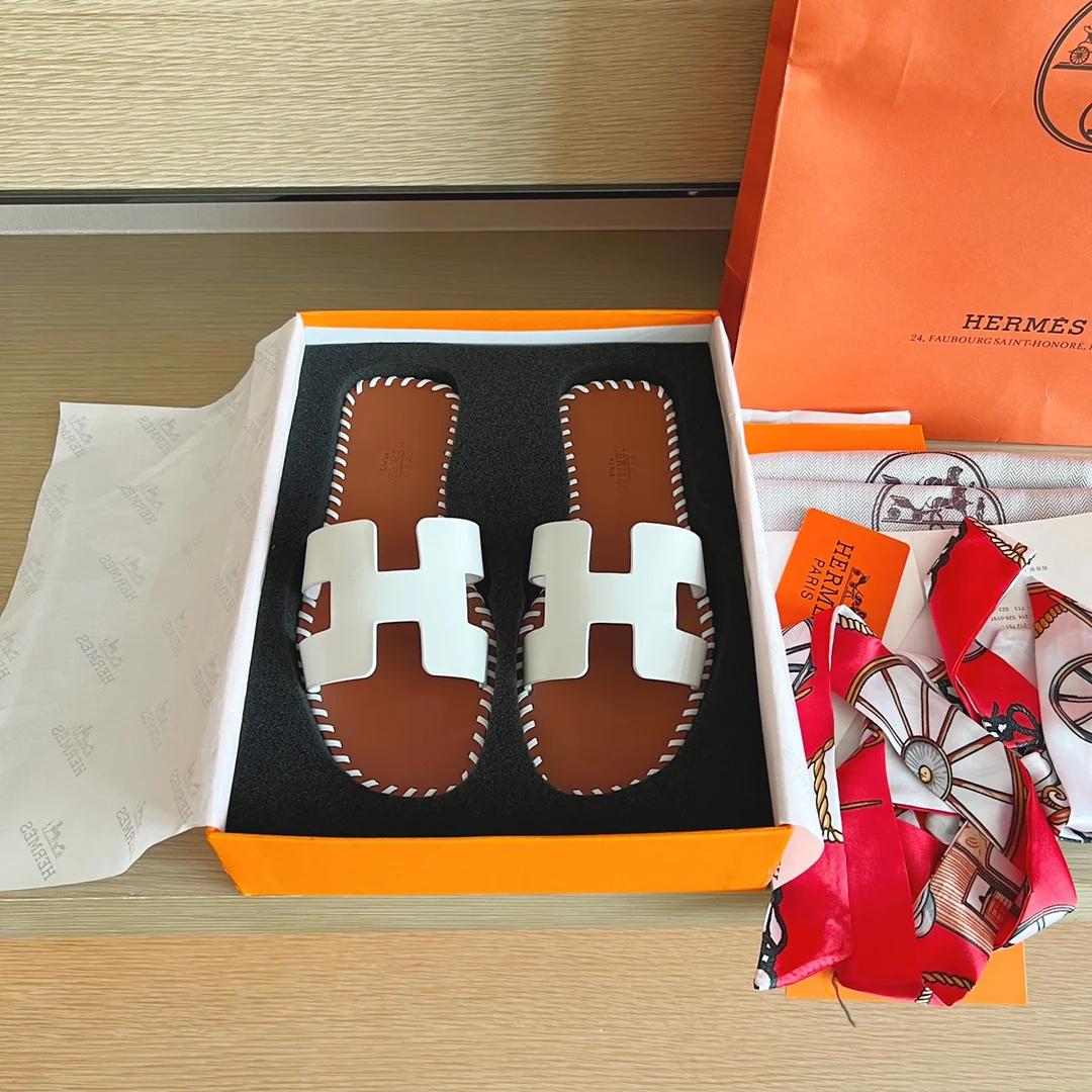 Классические домашние тапочки Hermes с буквой H — верх из однотонной кожи с прошитой подошвой — белые.
