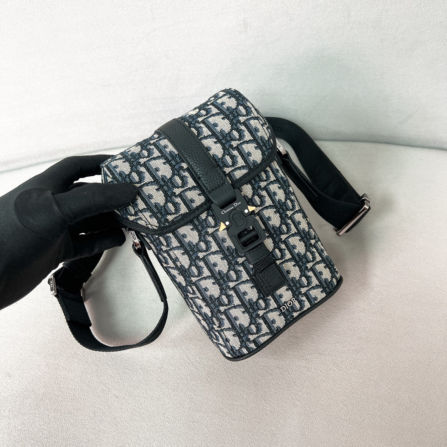 Сумка-мессенджер Dior Hittheroad Straight Flip — черная с зернистой отделкой.