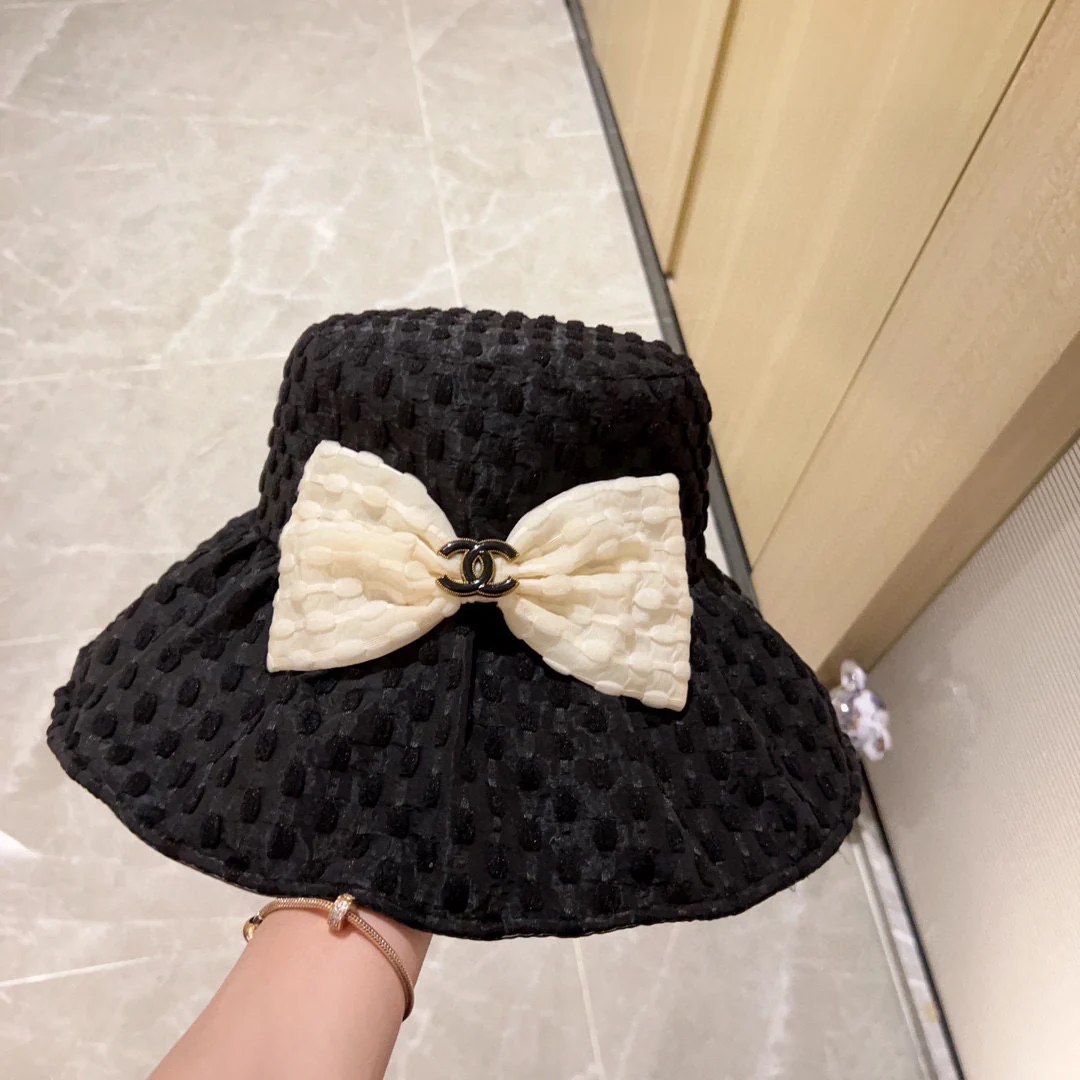 Новая коллекция Chanel 2023 года: плетеная рыбацкая шляпа с широкими полями и бантом, черная, начало осени.