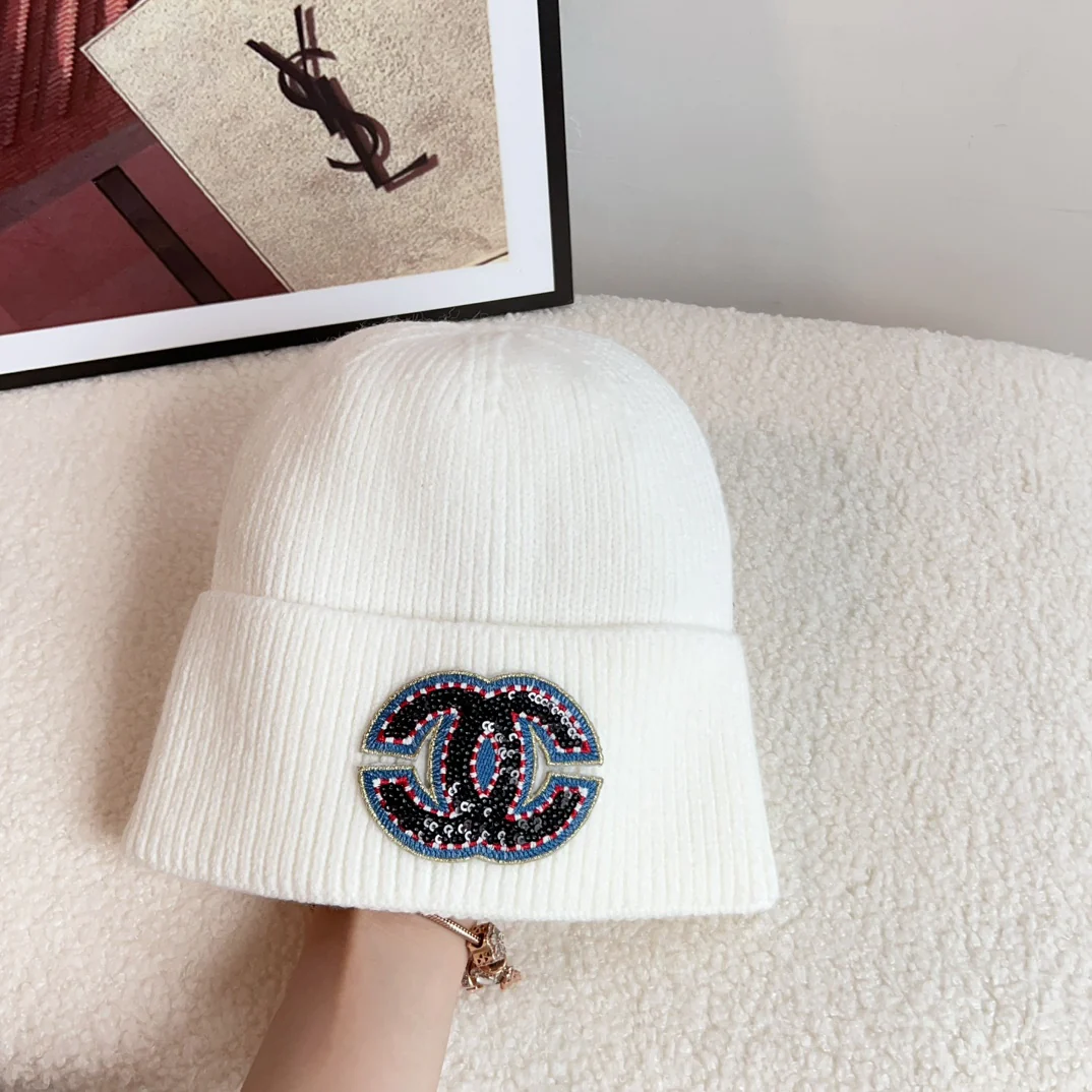 Новая плетеная шапка Chanel из коллекции осень/зима 2023 с ярким логотипом — белая.