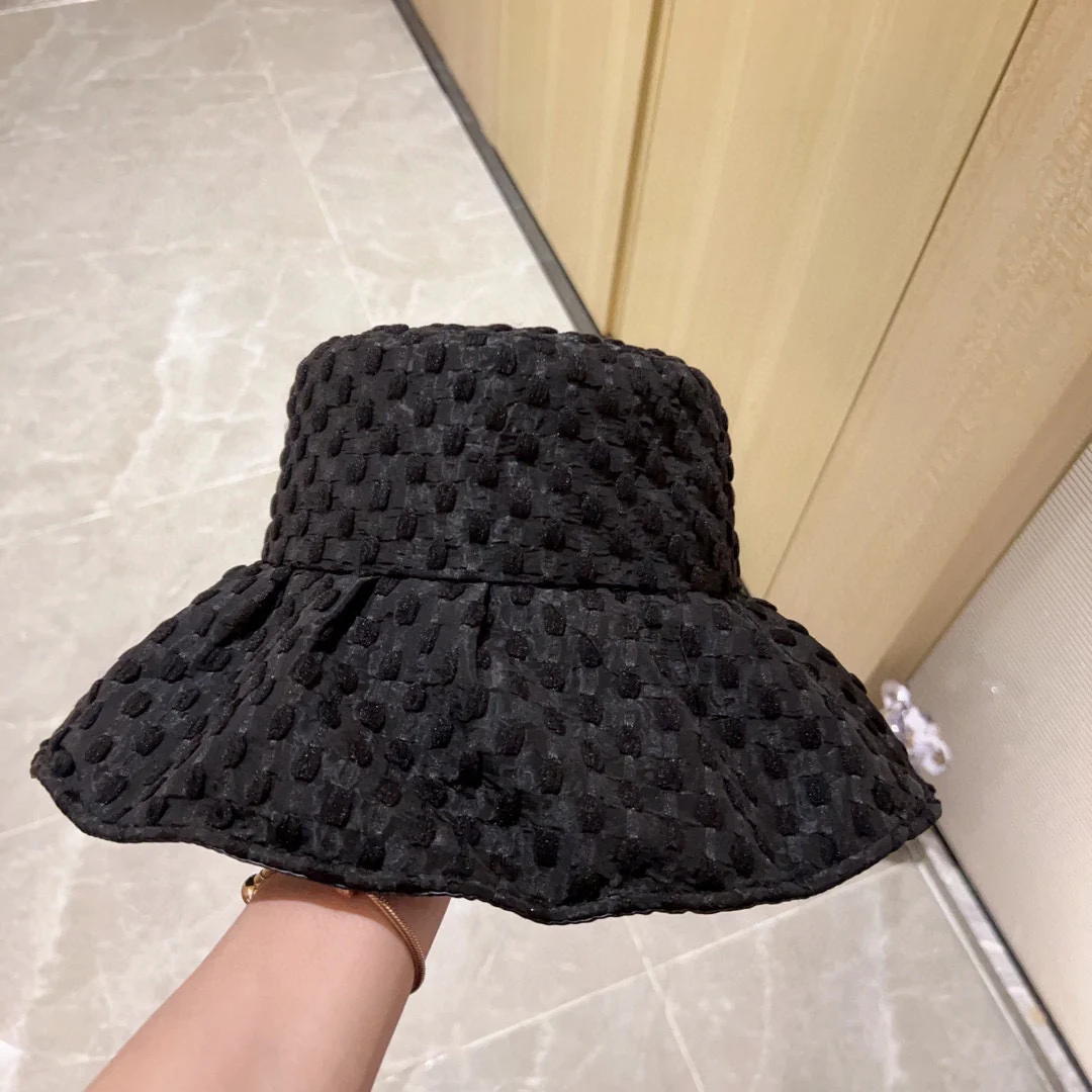 Новая коллекция Chanel 2023 года: плетеная рыбацкая шляпа с широкими полями и бантом, черная, начало осени.