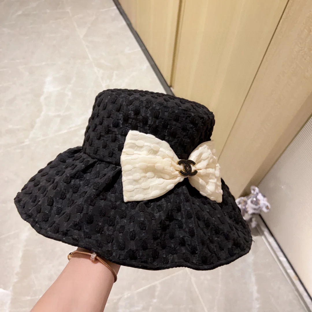 Новая коллекция Chanel 2023 года: плетеная рыбацкая шляпа с широкими полями и бантом, черная, начало осени.