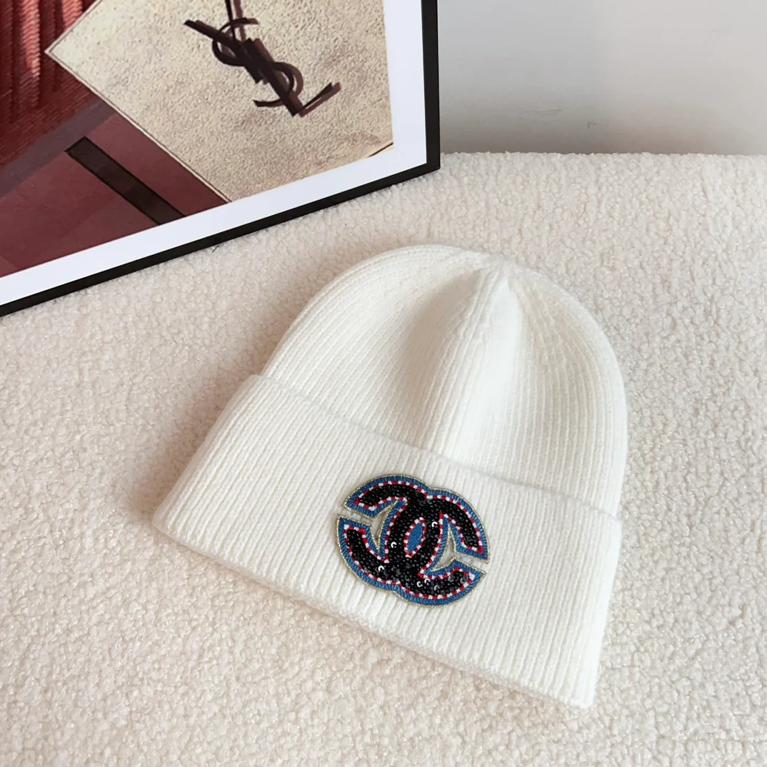 Новая плетеная шапка Chanel из коллекции осень/зима 2023 с ярким логотипом — белая.