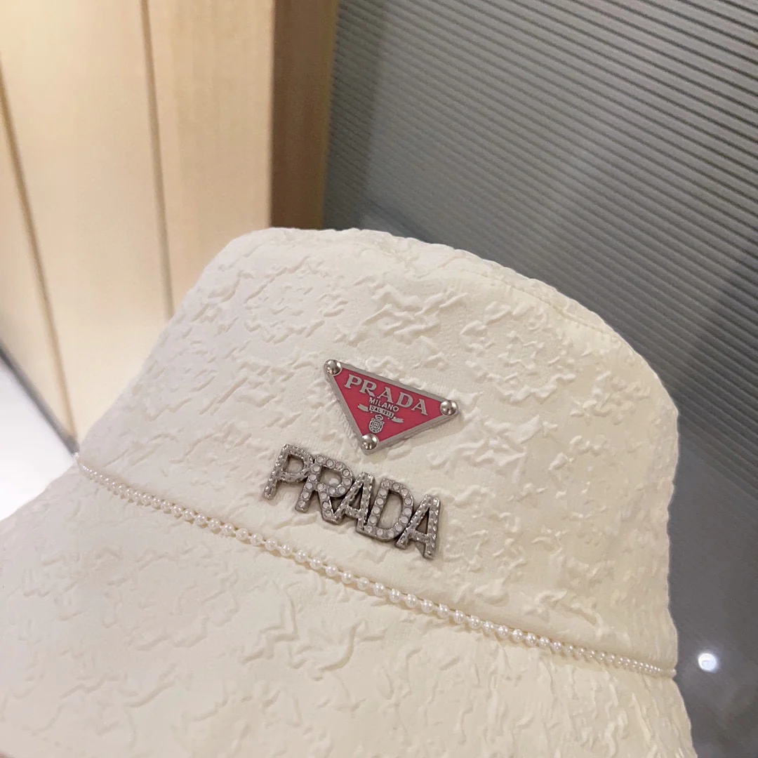 Новая рыбацкая шляпа Prada 2023 в стиле Chanel с жемчужной цепочкой — белая.