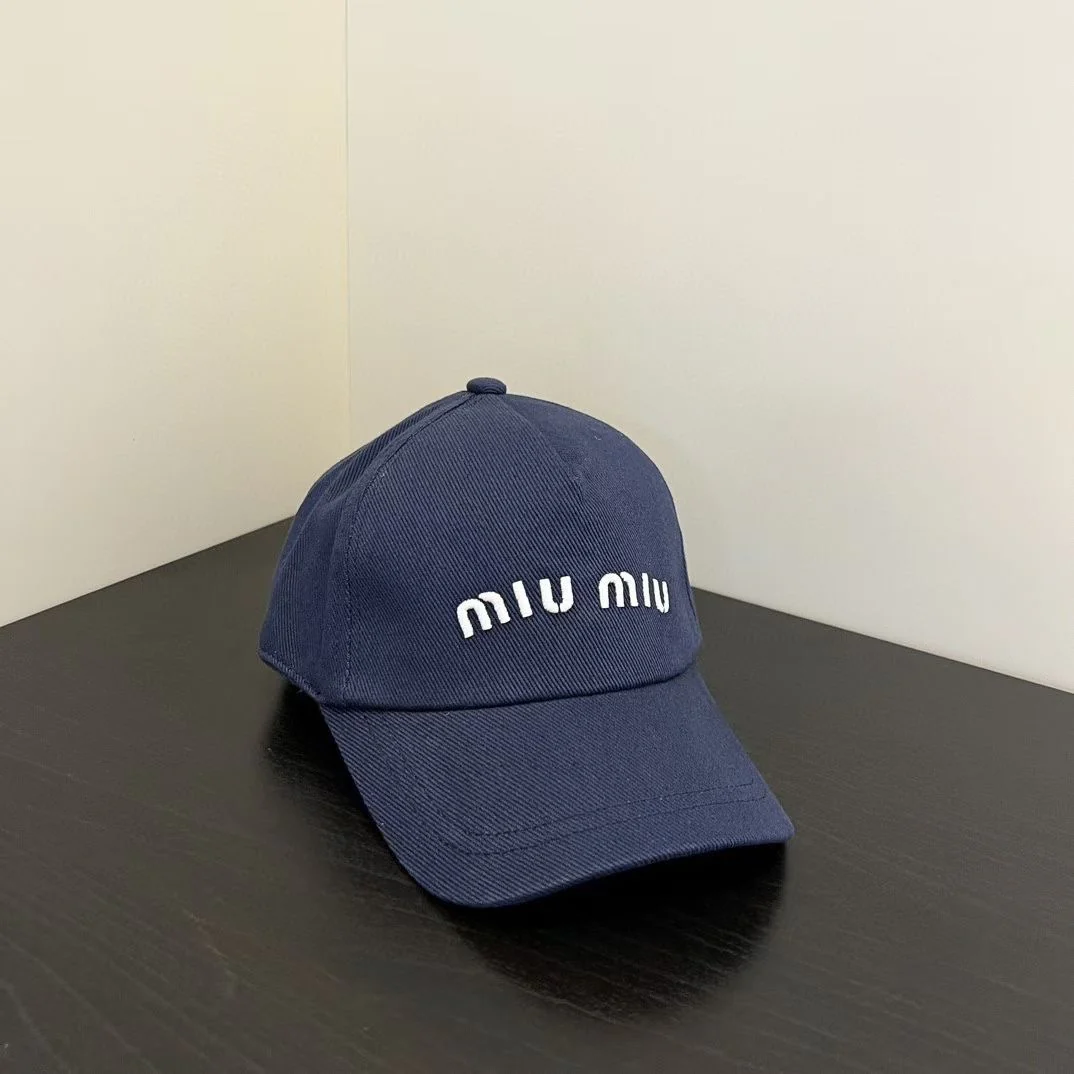 Бейсболка с вышитым логотипом Miu Miu — темно-синяя.
