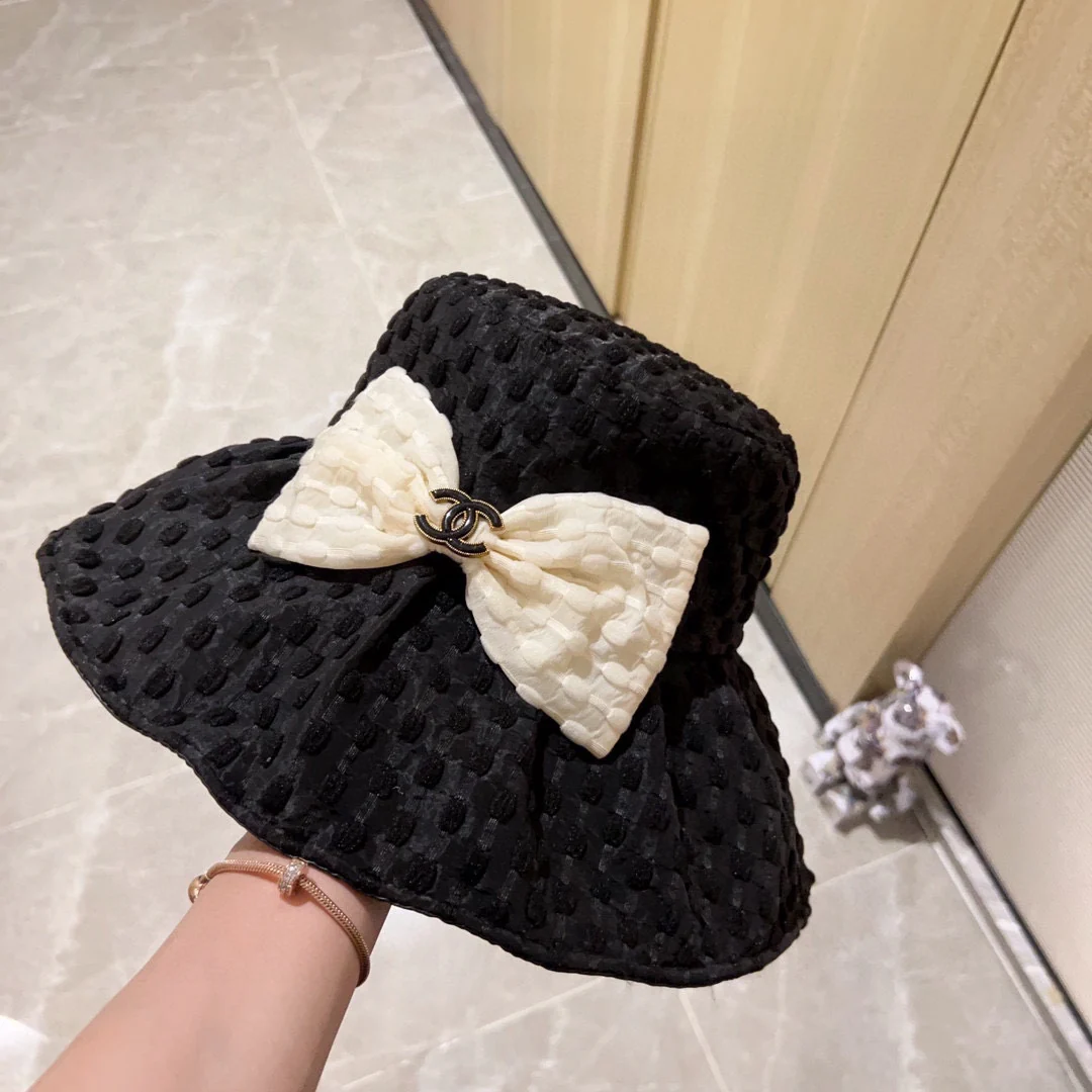 Новая коллекция Chanel 2023 года: плетеная рыбацкая шляпа с широкими полями и бантом, черная, начало осени.