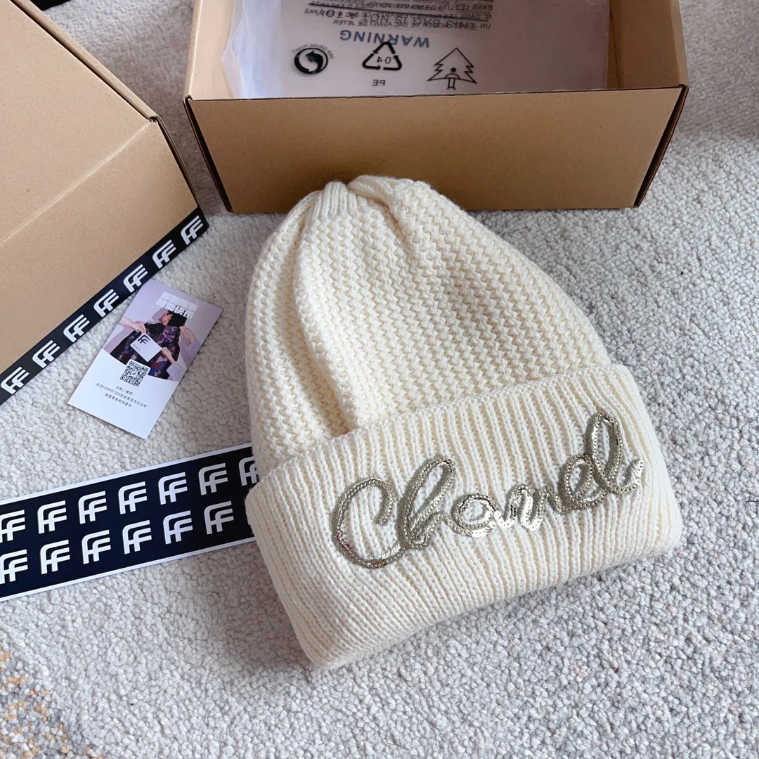 Шапка Chanel с плетеным узором в виде курсивных букв, украшенная пайетками, белая.