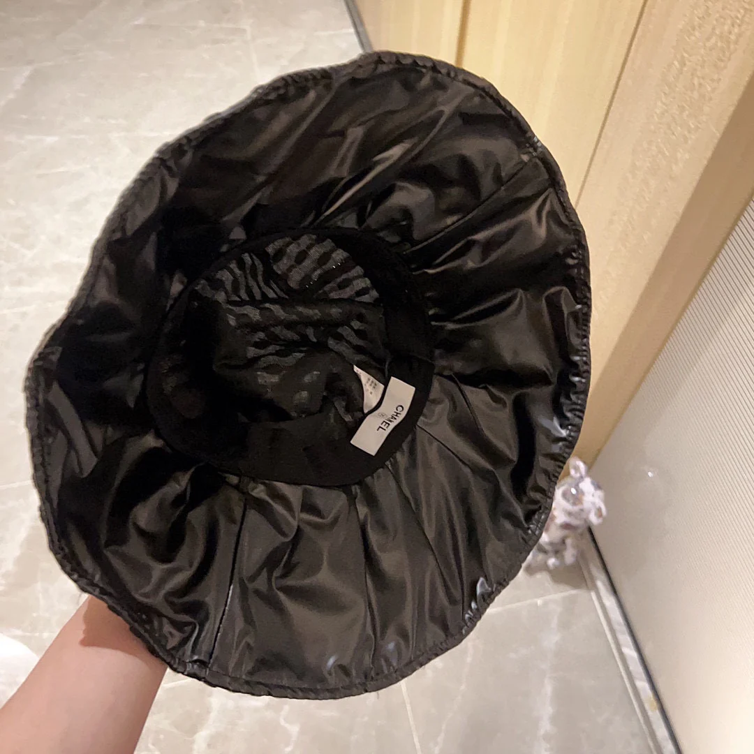 Новая коллекция Chanel 2023 года: плетеная рыбацкая шляпа с широкими полями и бантом, черная, начало осени.