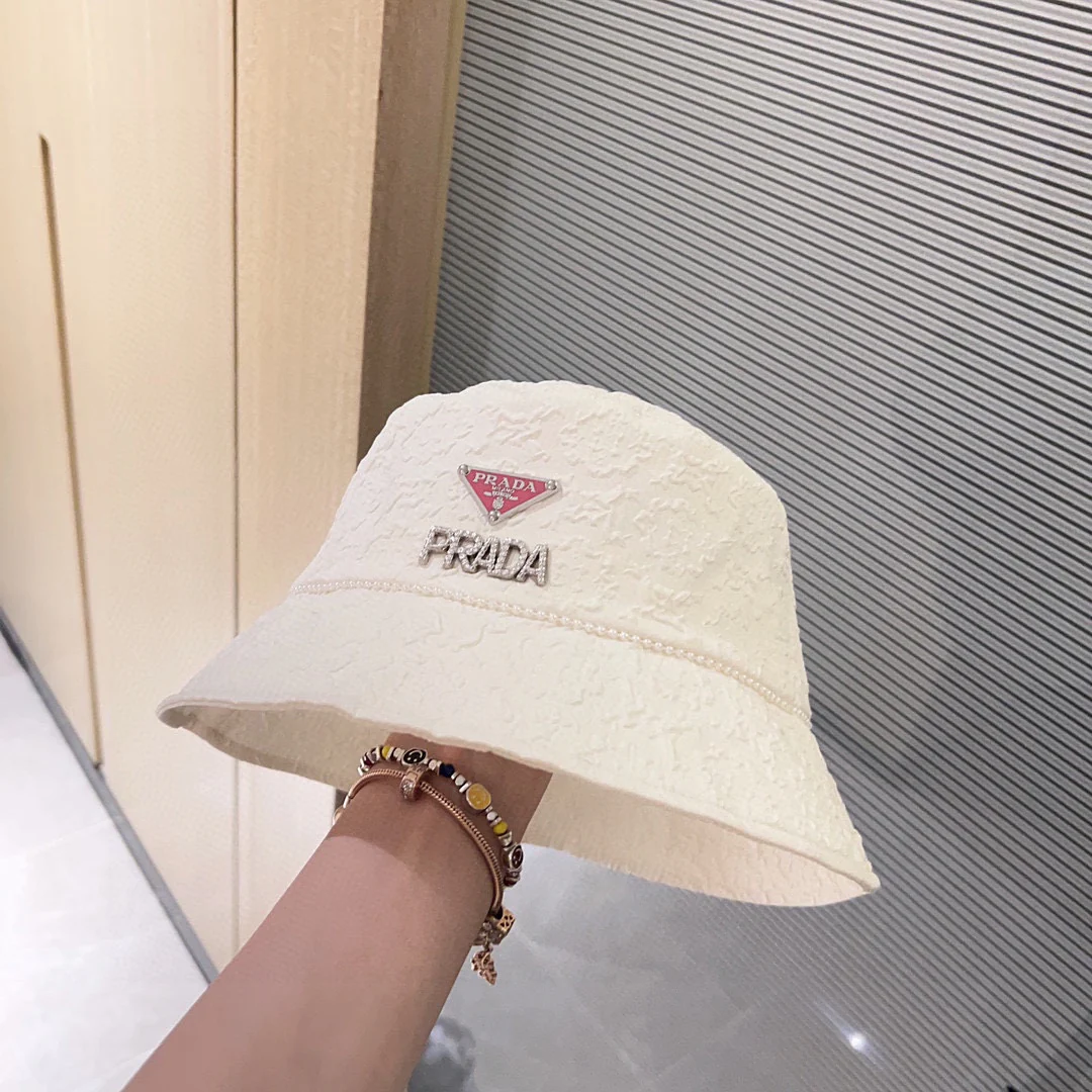 Новая рыбацкая шляпа Prada 2023 в стиле Chanel с жемчужной цепочкой — белая.