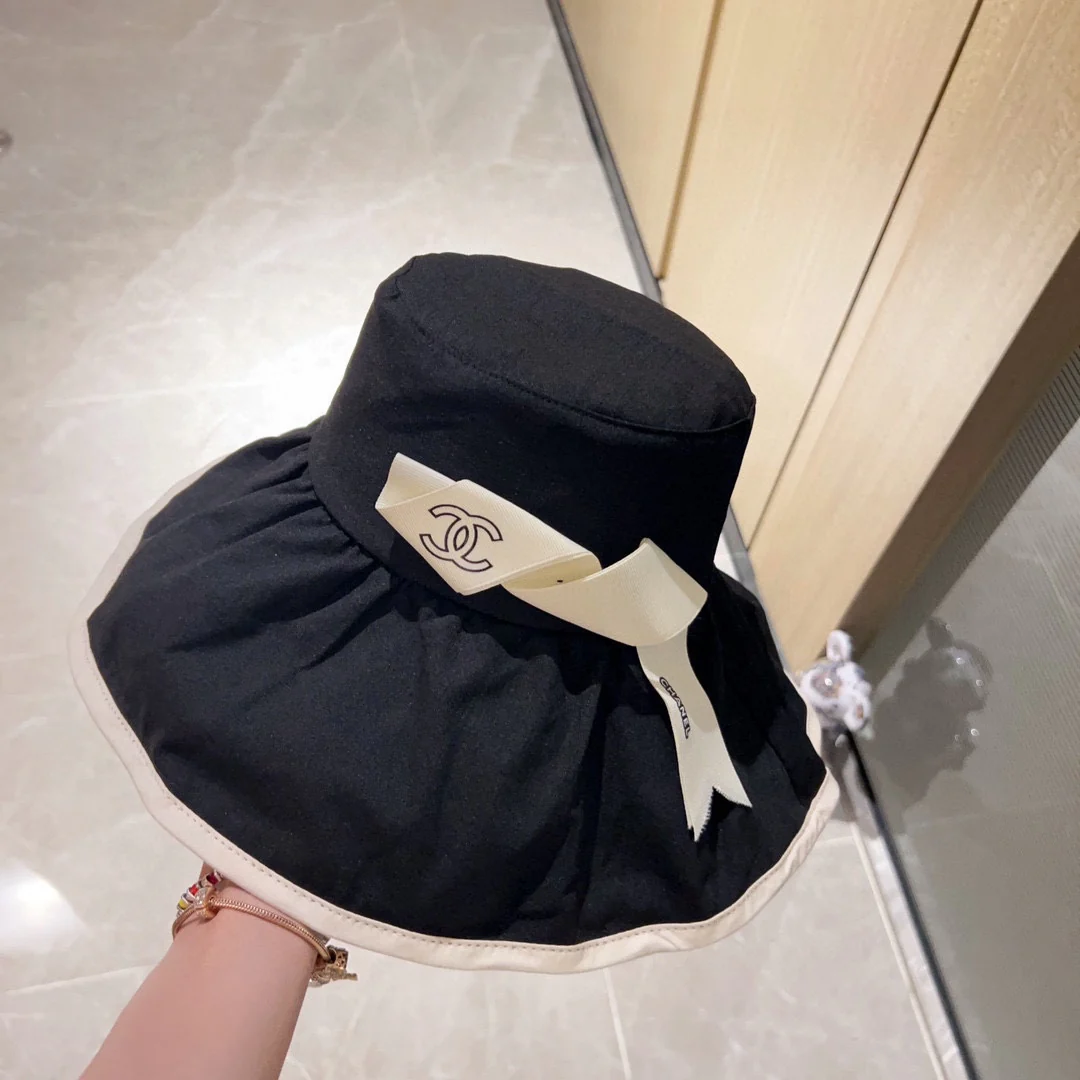 Новая коллекция Chanel 2023 года: широкополая рыбацкая шляпа с бантом в курортном стиле - черная.