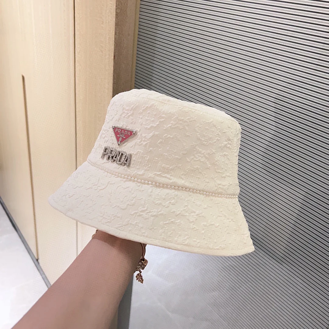 Новая рыбацкая шляпа Prada 2023 в стиле Chanel с жемчужной цепочкой — белая.