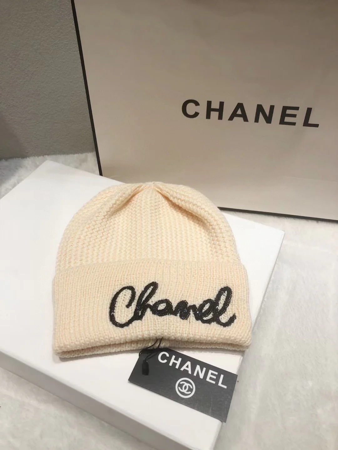 Вязаная шапка Chanel с пайетками и курсивной надписью