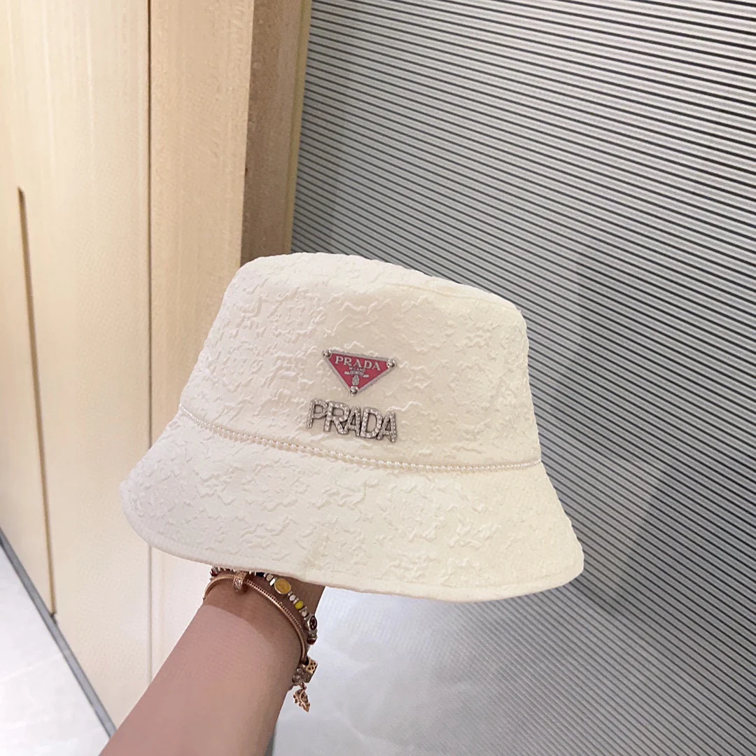 Новая рыбацкая шляпа Prada 2023 в стиле Chanel с жемчужной цепочкой — белая.