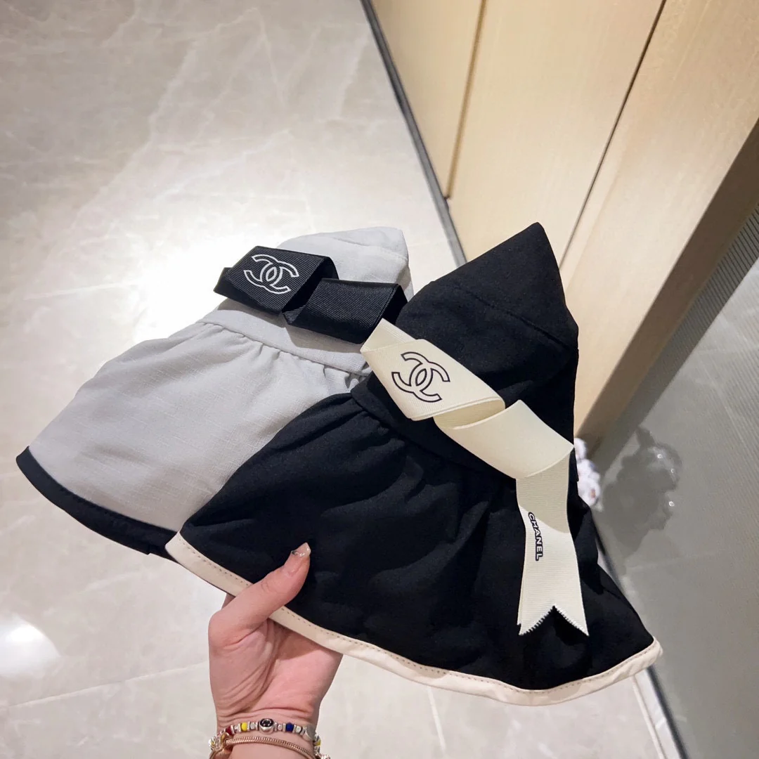 Новая коллекция Chanel 2023 года: широкополая рыбацкая шляпа с бантом в курортном стиле - черная.