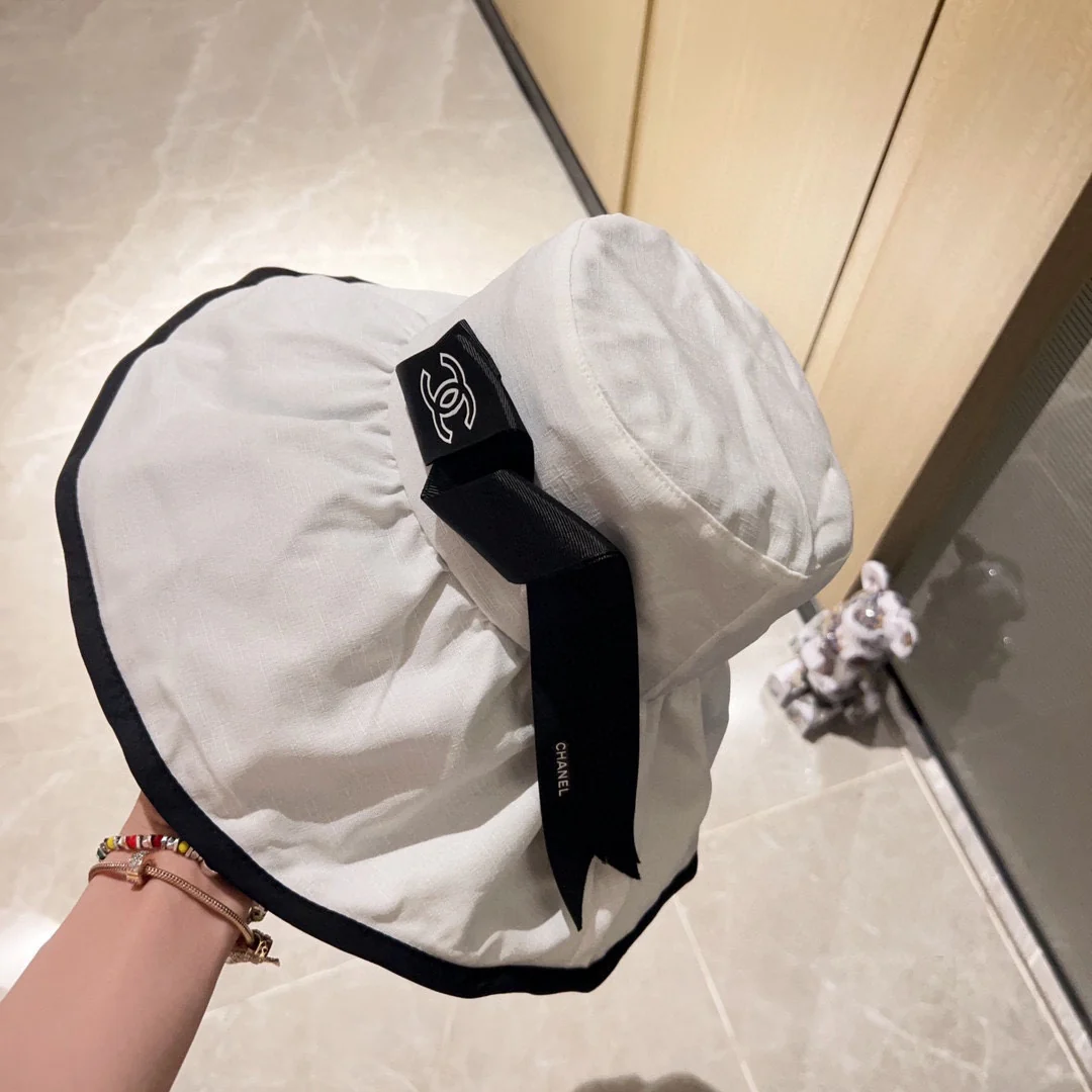 Новая коллекция Chanel 2023 года: широкополая рыбацкая шляпа с бантом в курортном стиле - белая.