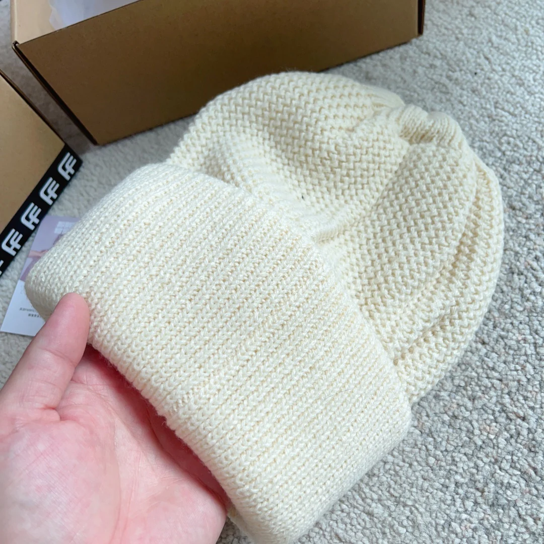 Шапка Chanel с плетеным узором в виде курсивных букв, украшенная пайетками, белая.