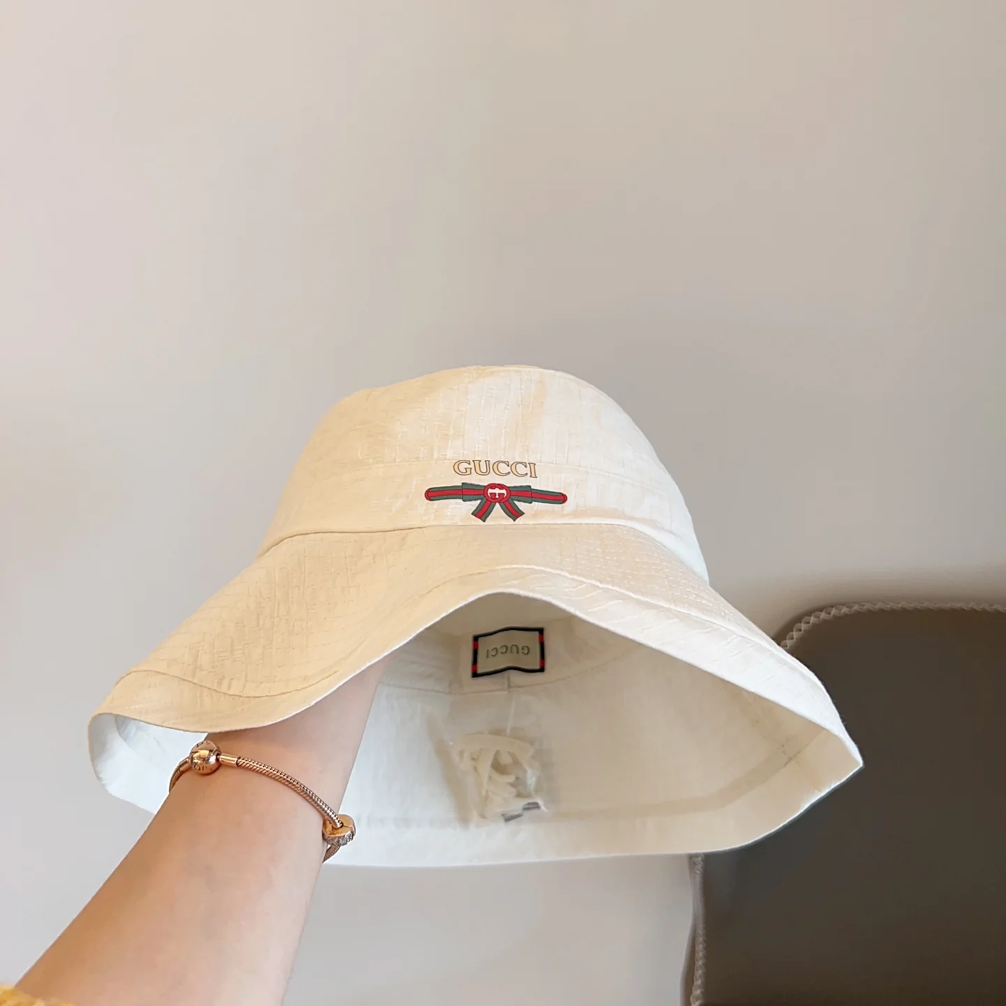 Рыбацкая шляпа Gucci с загнутыми полями и складками — белая.