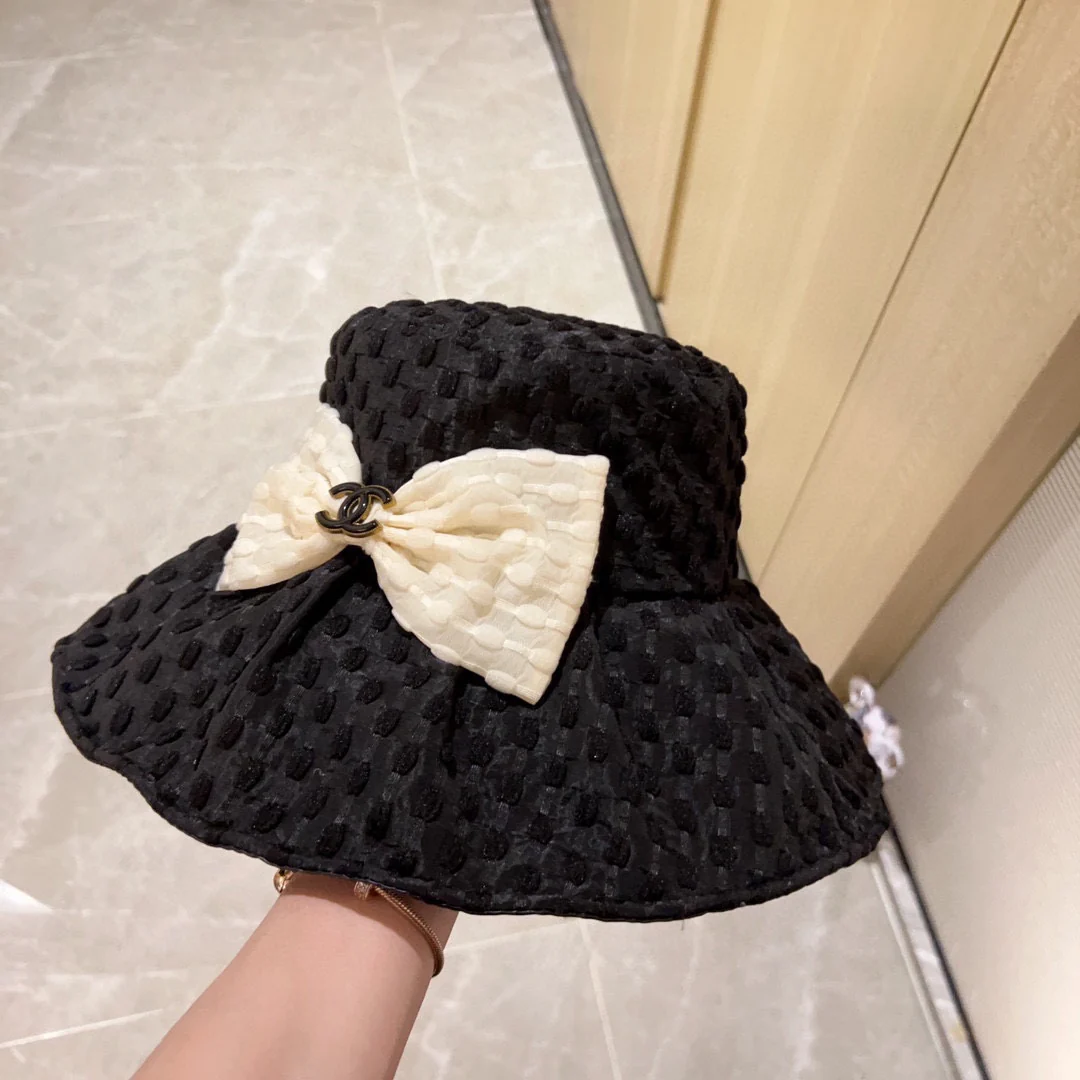 Новая коллекция Chanel 2023 года: плетеная рыбацкая шляпа с широкими полями и бантом, черная, начало осени.