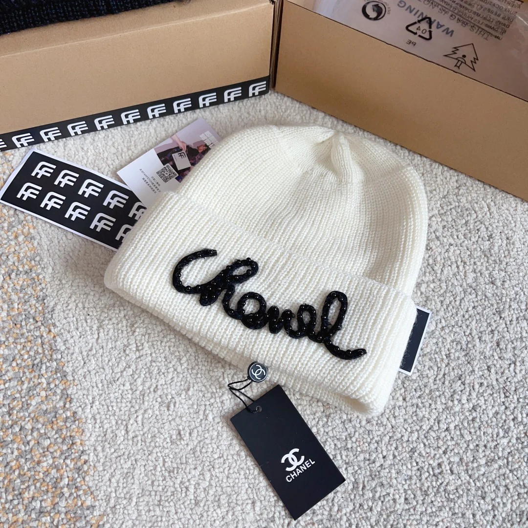 Плетеная шляпа Chanel с надписью курсивом — белая.