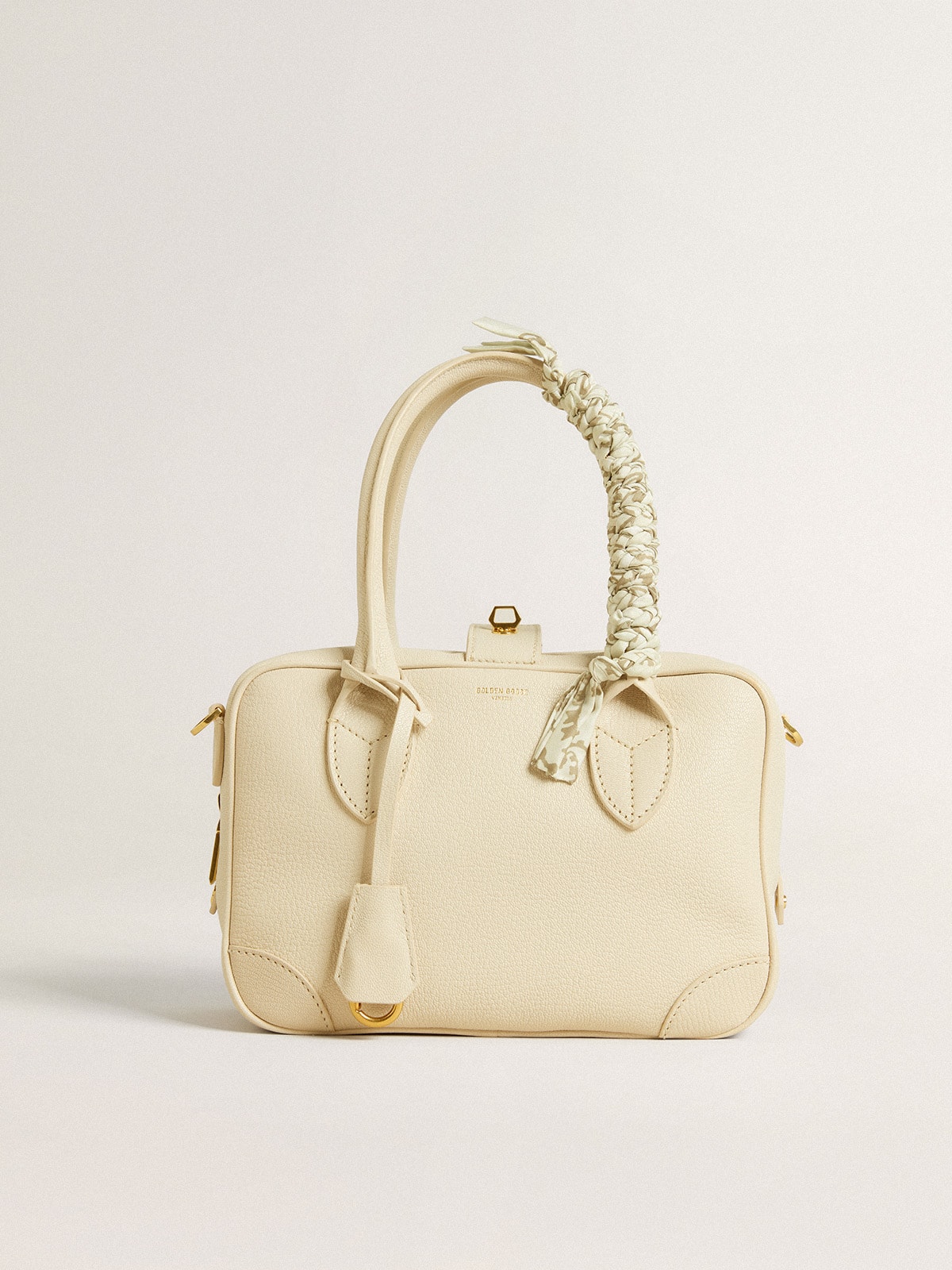 Butter-colored braided fabric charm with brass chain