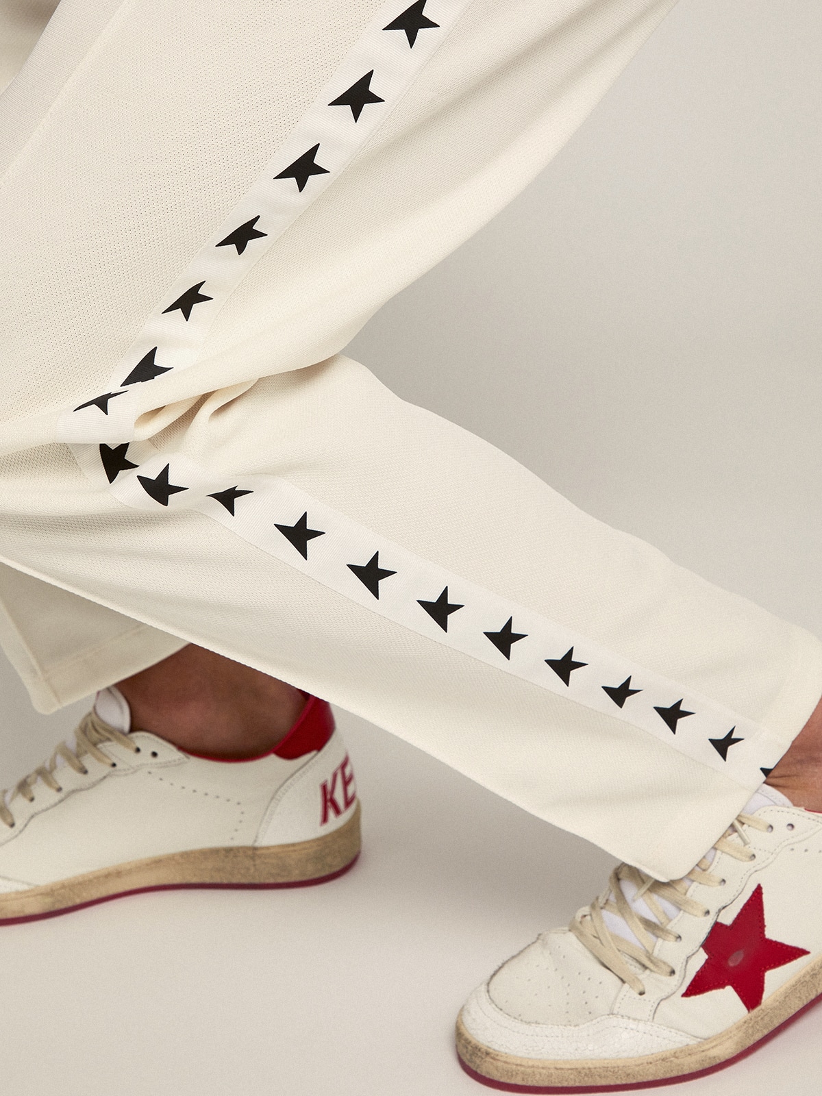 Men's white joggers with black stars on the sides