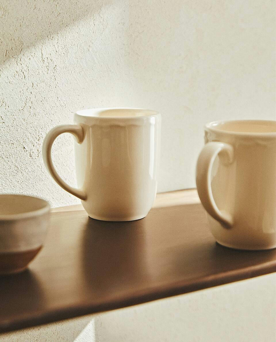 EARTHENWARE MUG WITH A RAISED-DESIGN EDGE